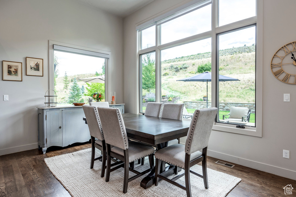 Dining room with baseboards and dark wood-style flooring