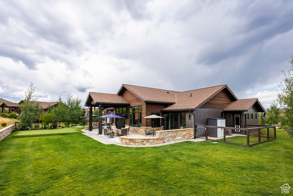 Rear view of property with a patio area and roof with shingles