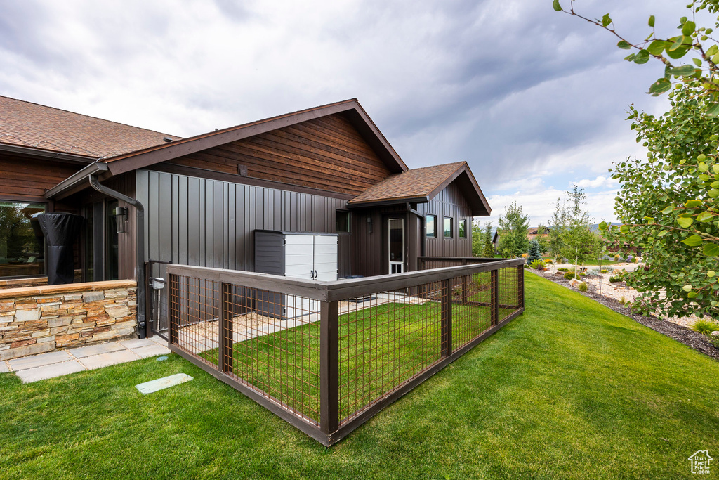 View of property exterior featuring a yard and a shingled roof