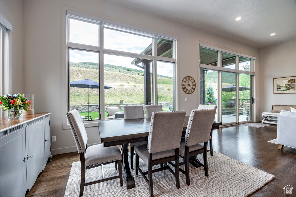 Dining space featuring recessed lighting, dark wood-style flooring, plenty of natural light, baseboards, and a mountain view