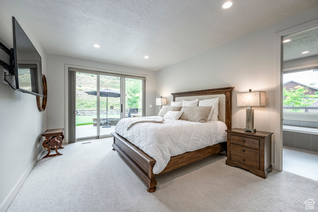 Carpeted bedroom featuring access to exterior, recessed lighting, a textured ceiling, and baseboards