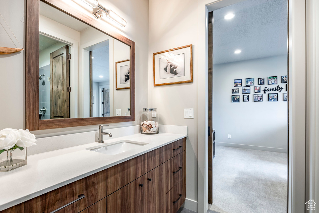 Bathroom featuring vanity, recessed lighting, and baseboards