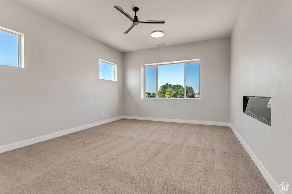 Carpeted empty room with ceiling fan