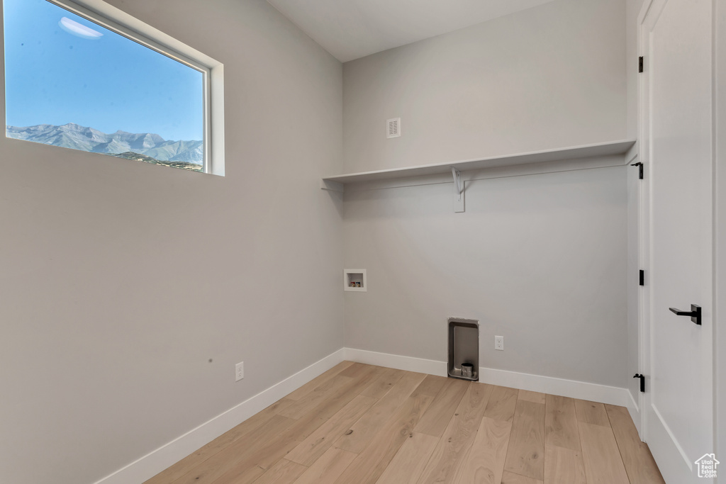 Laundry room featuring hookup for a washing machine and light hardwood / wood-style flooring