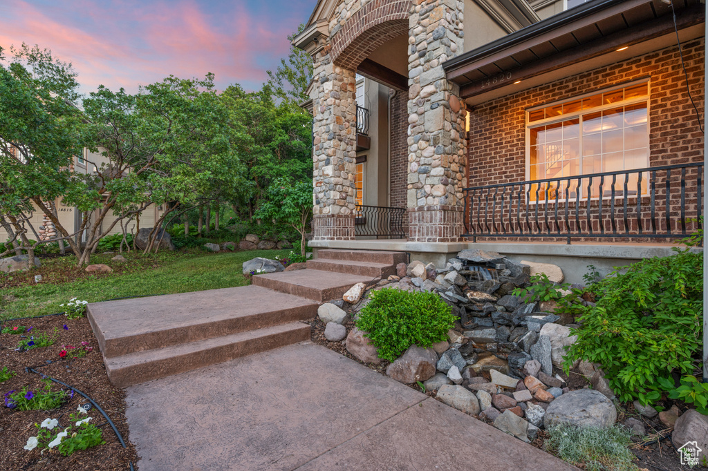 Exterior entry at dusk with brick siding and a porch