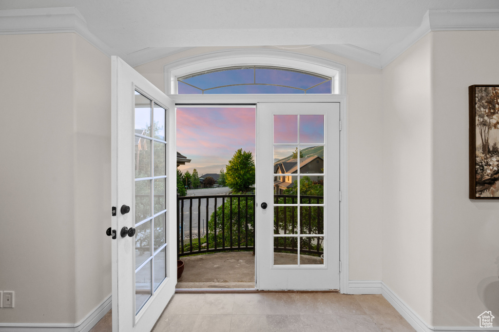 Entryway featuring ornamental molding, french doors, and vaulted ceiling