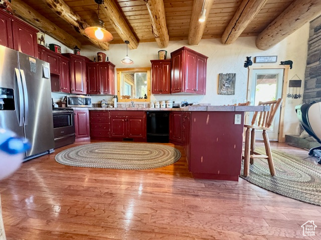 Kitchen featuring a healthy amount of sunlight, light wood-type flooring, wood ceiling, stainless steel appliances, and a kitchen bar