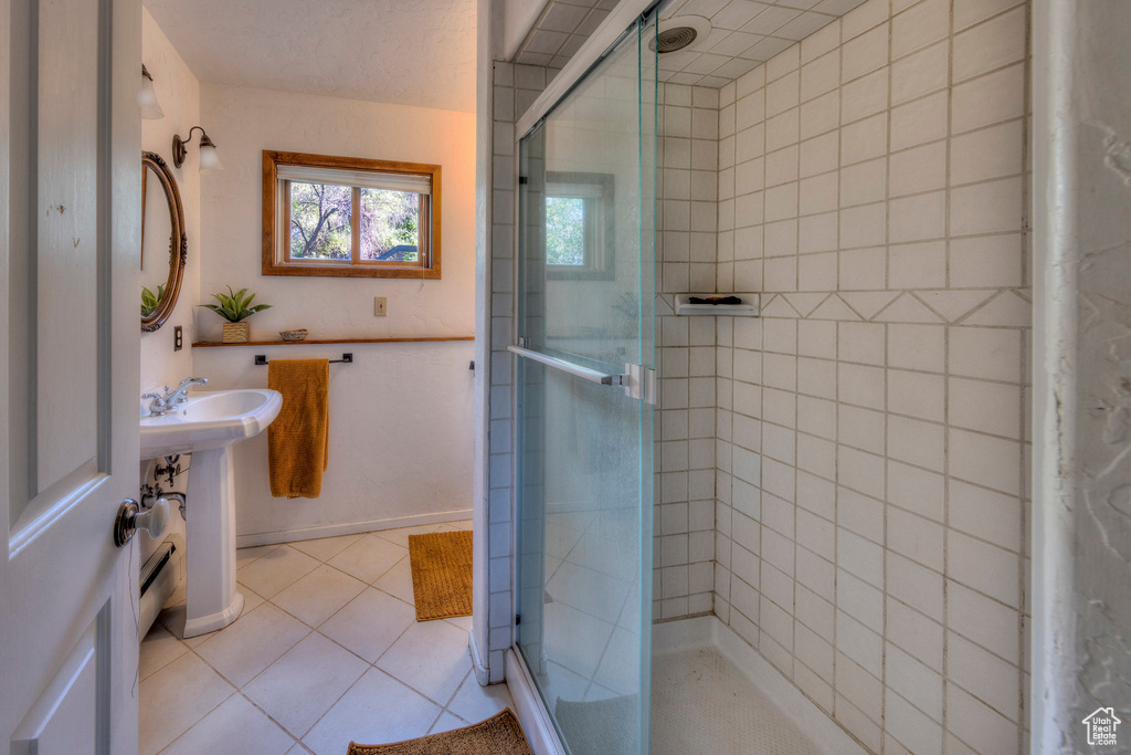 Full bathroom with a shower stall, tile patterned floors, and a sink