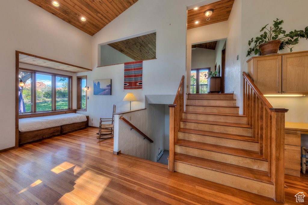 Stairway featuring wooden ceiling, recessed lighting, wood finished floors, and high vaulted ceiling