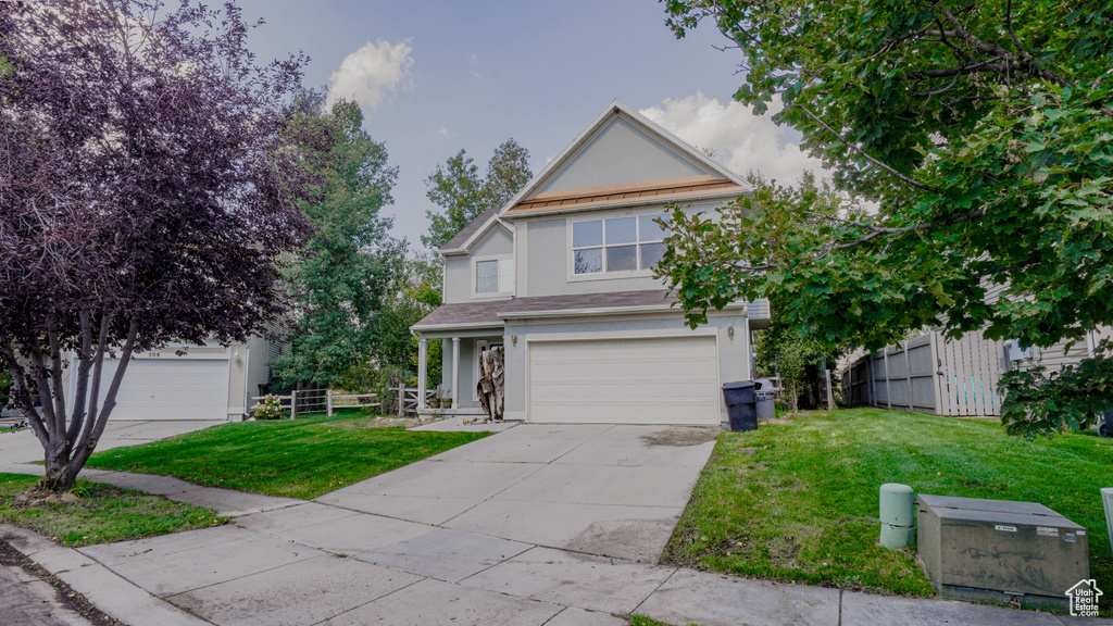 View of front of home with a garage and a front yard