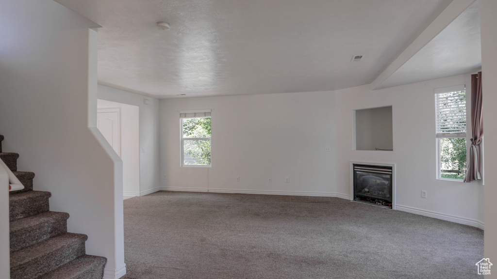 Unfurnished living room featuring light colored carpet