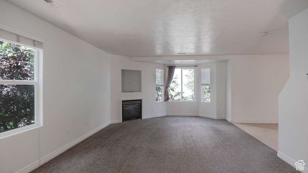 Unfurnished living room featuring carpet