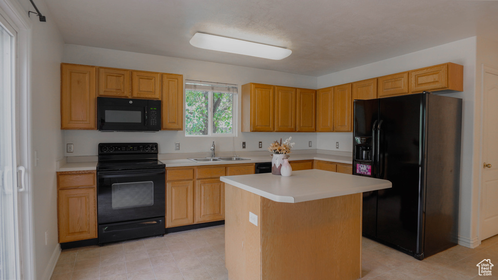 Kitchen featuring black appliances, a kitchen island, and sink