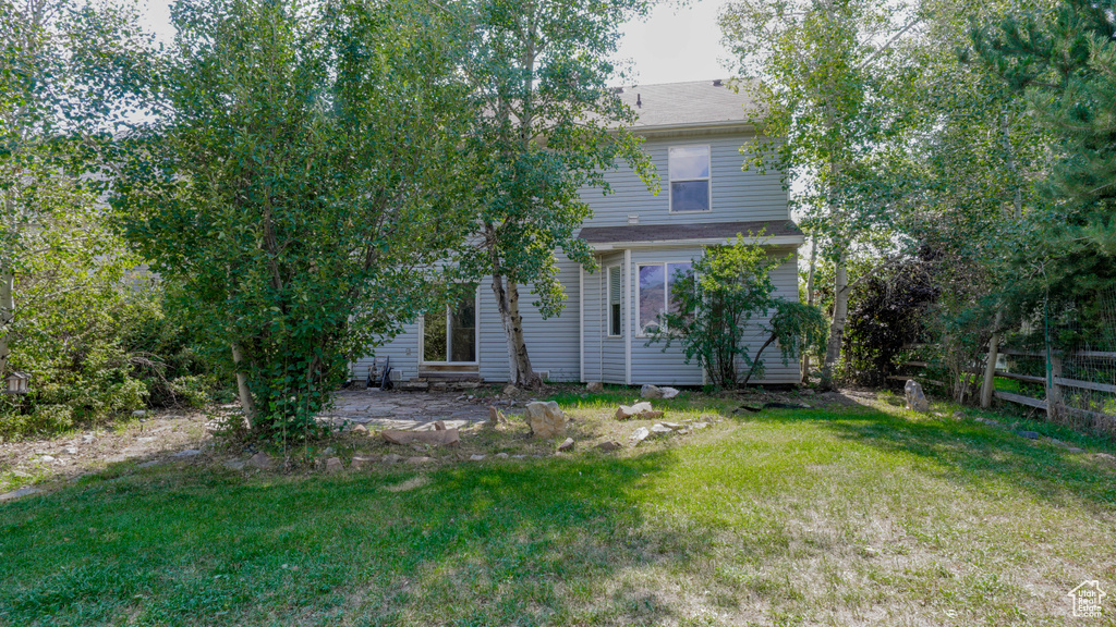 Back of property with a yard and a patio