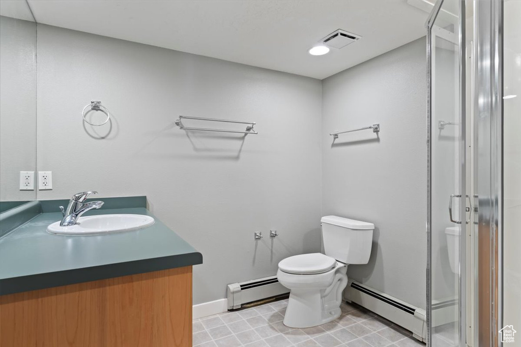 Bathroom with a baseboard heating unit, a stall shower, visible vents, and toilet