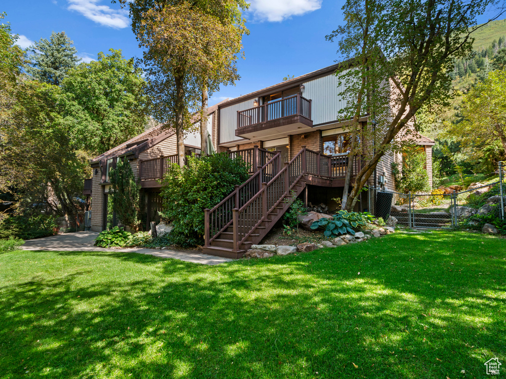 Back of house featuring a yard and a deck