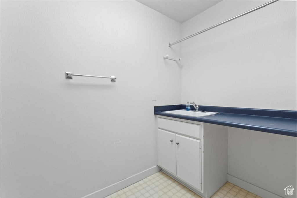 Bathroom with vanity, baseboards, and tile patterned floors