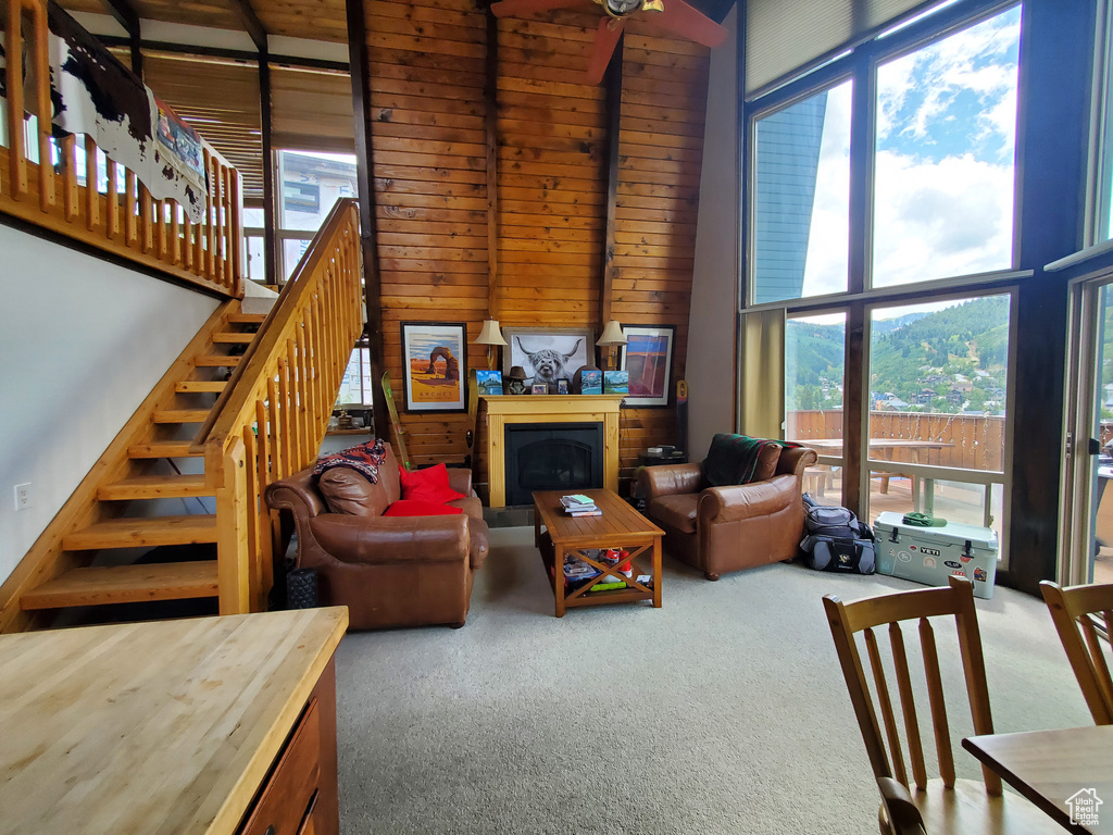 Carpeted living room featuring a towering ceiling