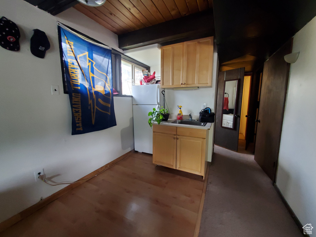 Kitchen with dark hardwood / wood-style floors, white fridge, wooden ceiling, sink, and light brown cabinets