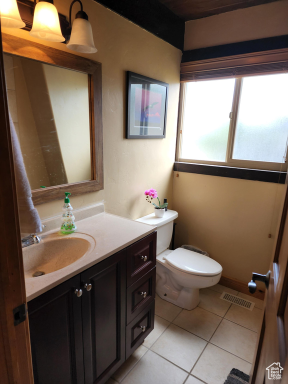 Bathroom featuring vanity, toilet, and tile patterned flooring