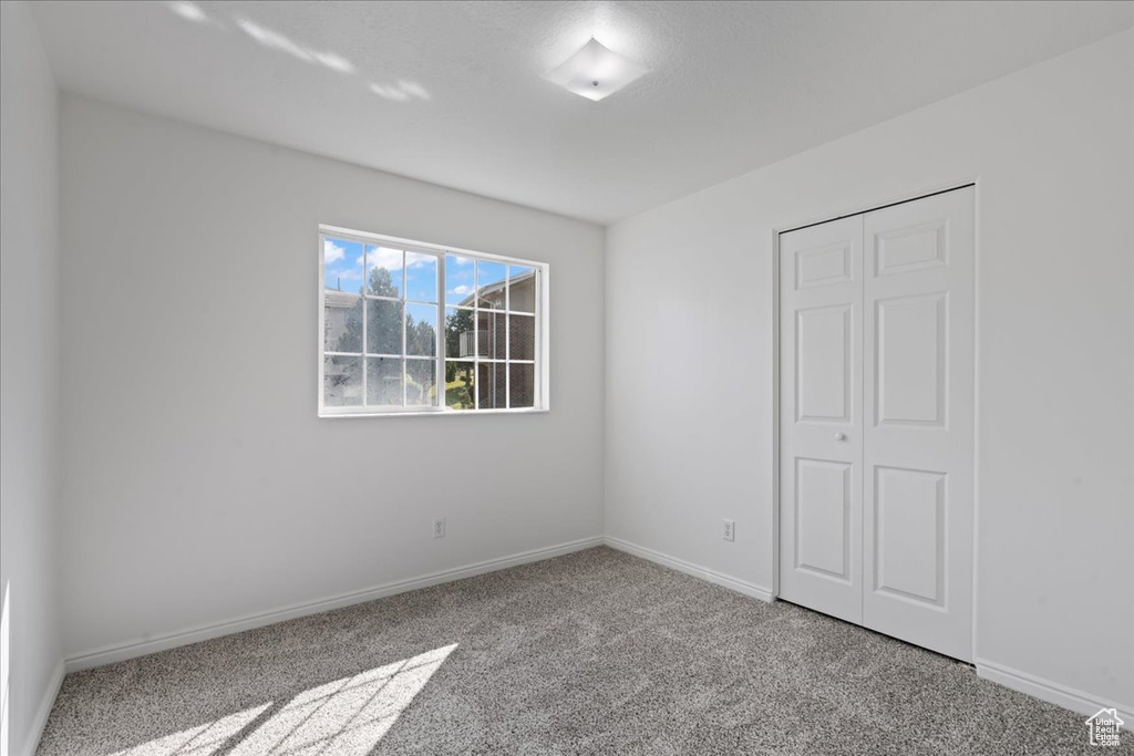 Unfurnished bedroom featuring carpet and a closet