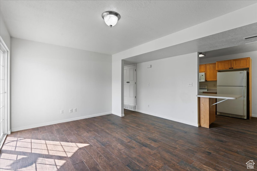 Interior space featuring a textured ceiling and dark hardwood / wood-style floors