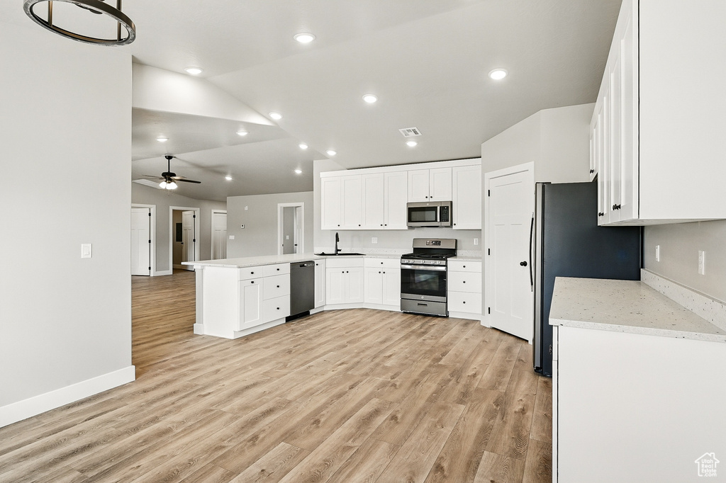 Kitchen featuring ceiling fan, a peninsula, white cabinetry, appliances with stainless steel finishes, and a sink