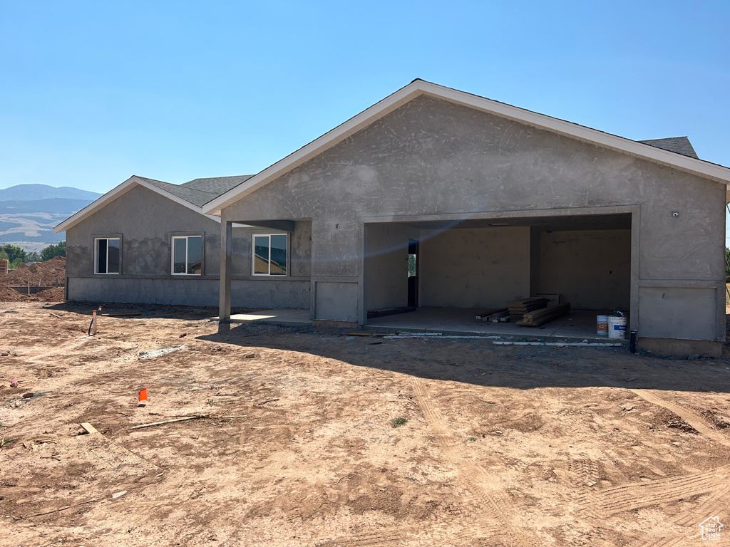 Back of house with a mountain view and a garage