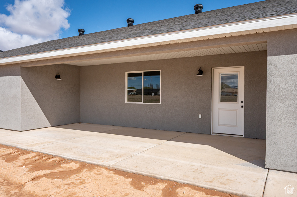 View of exterior entry featuring a patio area and stucco siding