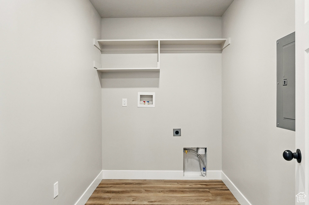 Laundry area featuring hookup for an electric dryer, electric panel, washer hookup, laundry area, and wood finished floors