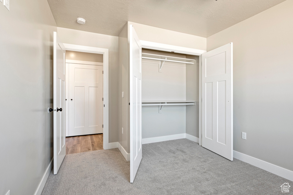 Unfurnished bedroom featuring light colored carpet and a closet