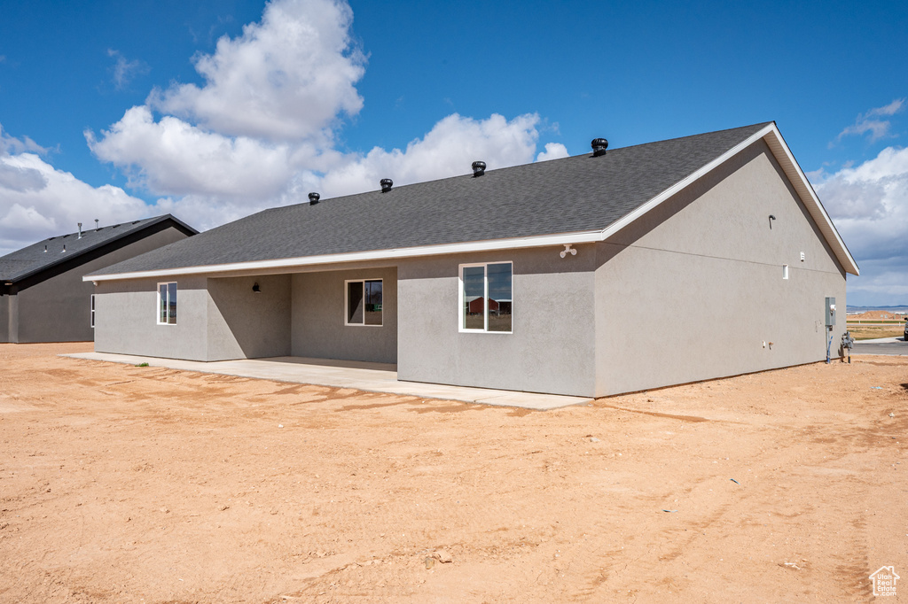Back of property with a patio and stucco siding