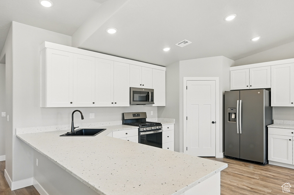 Kitchen with recessed lighting, a peninsula, visible vents, appliances with stainless steel finishes, and a sink