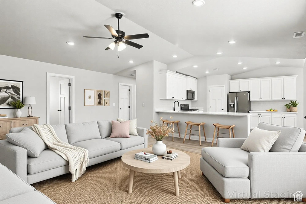 Living room with a ceiling fan, visible vents, recessed lighting, wood finished floors, and lofted ceiling
