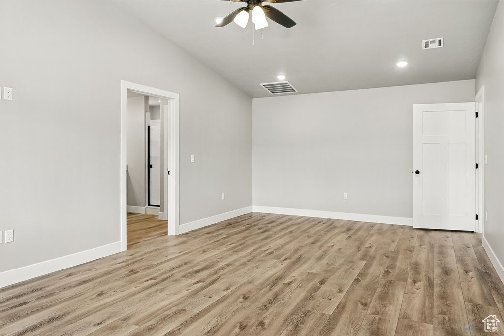 Spare room with visible vents, baseboards, ceiling fan, light wood finished floors, and vaulted ceiling