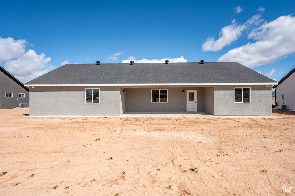 Back of property with a patio, roof with shingles, and stucco siding