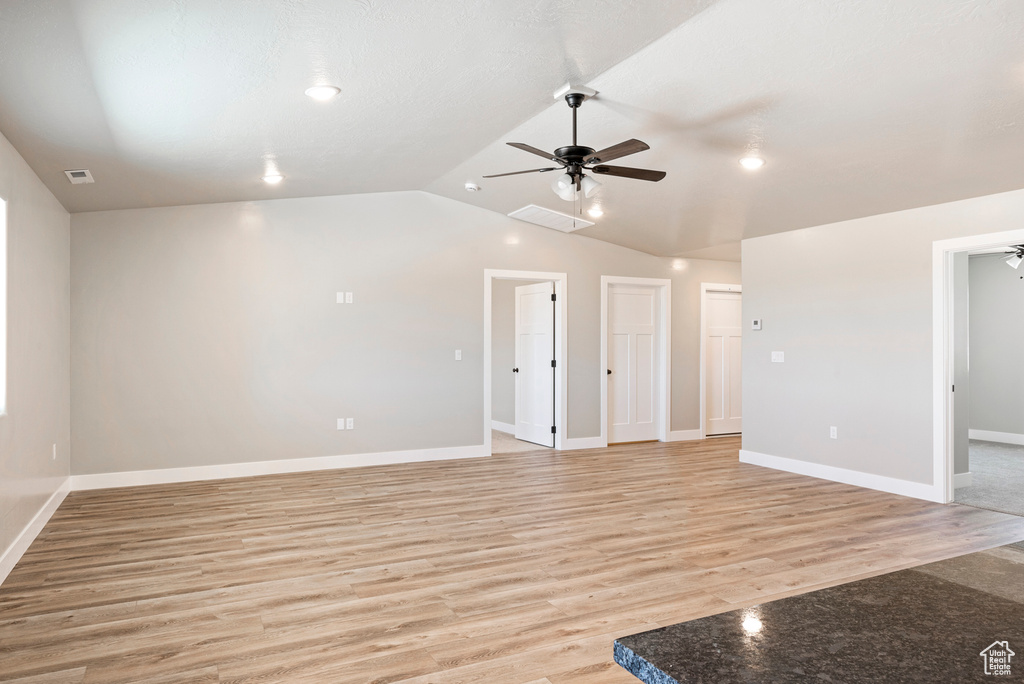 Spare room featuring ceiling fan, hardwood / wood-style flooring, and vaulted ceiling