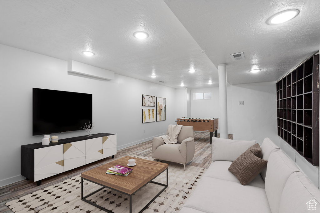 Living room featuring a textured ceiling and hardwood / wood-style floors