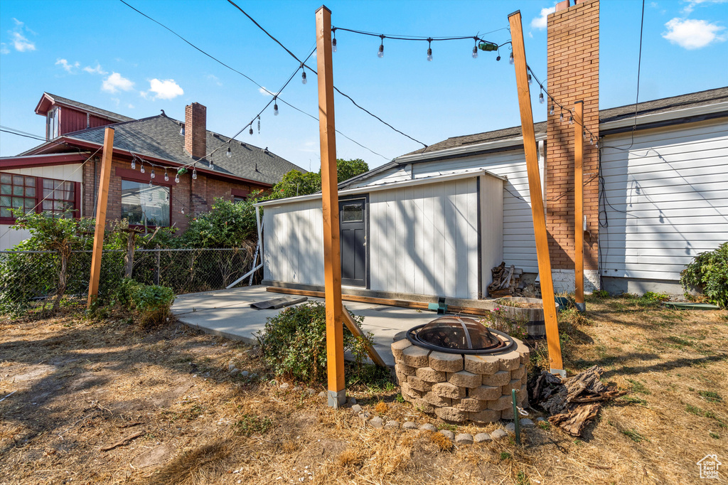 Rear view of property with a fire pit and a patio