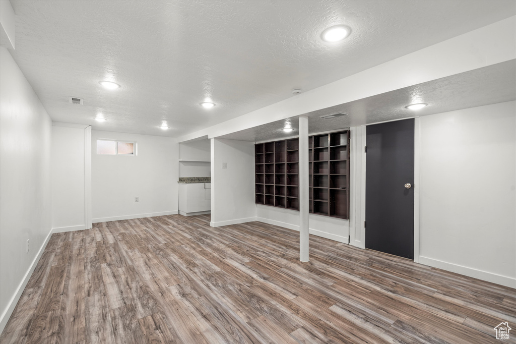 Basement with hardwood / wood-style flooring and a textured ceiling