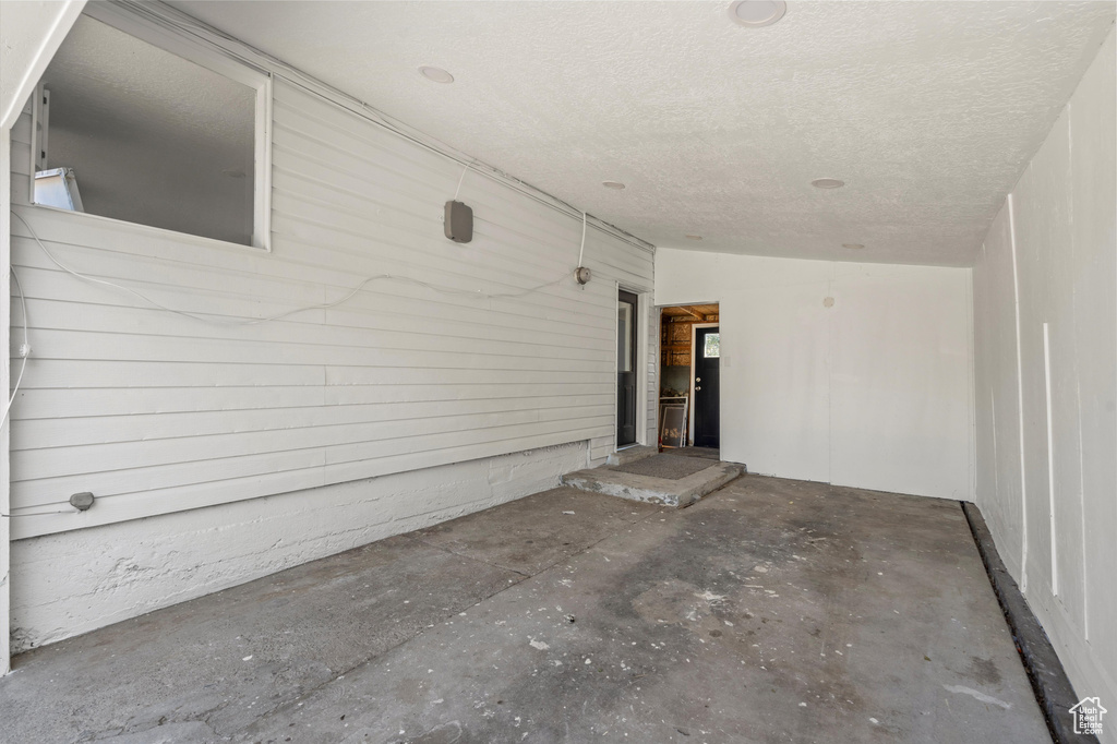 Interior space featuring a textured ceiling and concrete flooring