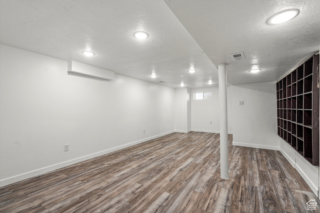 Basement featuring hardwood / wood-style floors and a textured ceiling