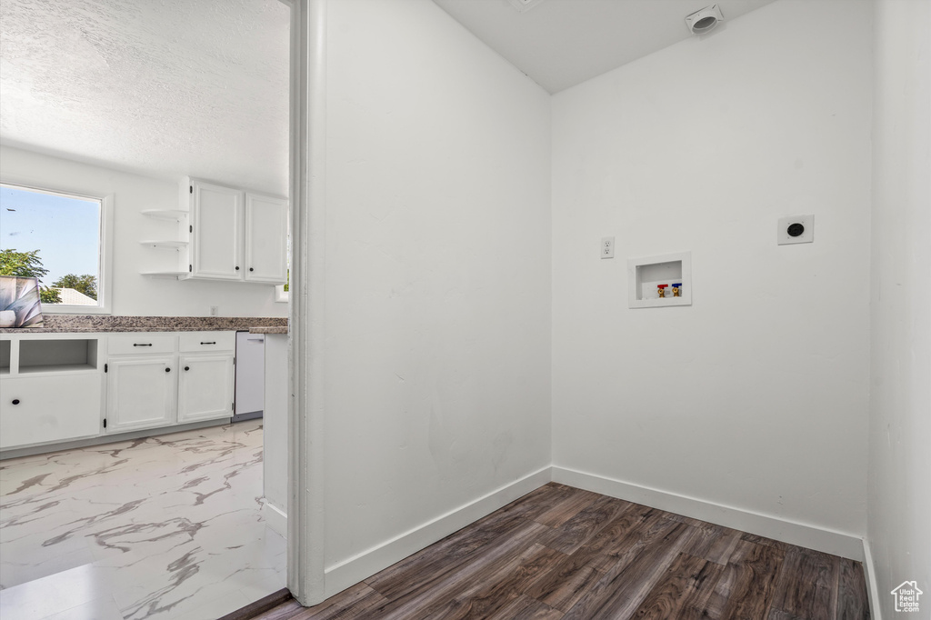 Laundry room featuring a textured ceiling, hardwood / wood-style floors, electric dryer hookup, and washer hookup