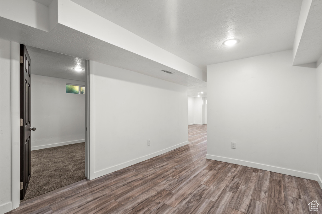 Spare room featuring a textured ceiling and hardwood / wood-style floors