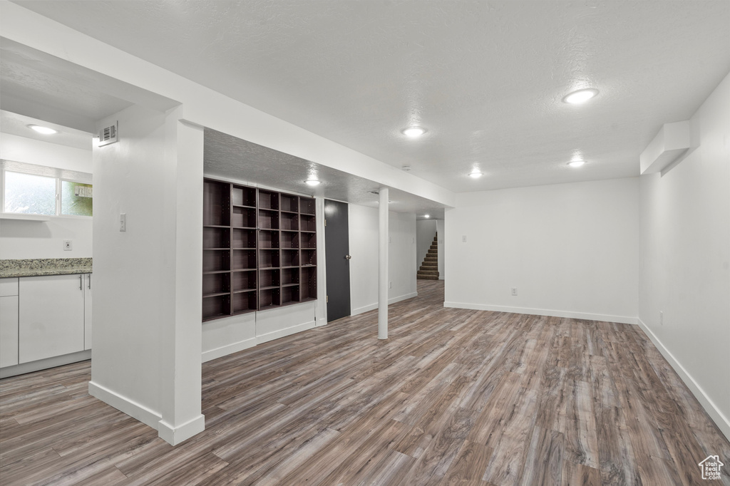 Unfurnished living room featuring hardwood / wood-style floors and a textured ceiling