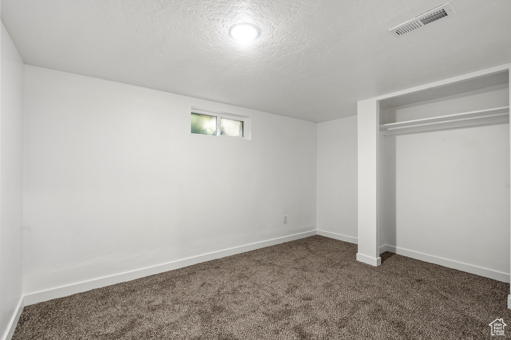 Unfurnished bedroom featuring a closet, a textured ceiling, and carpet floors