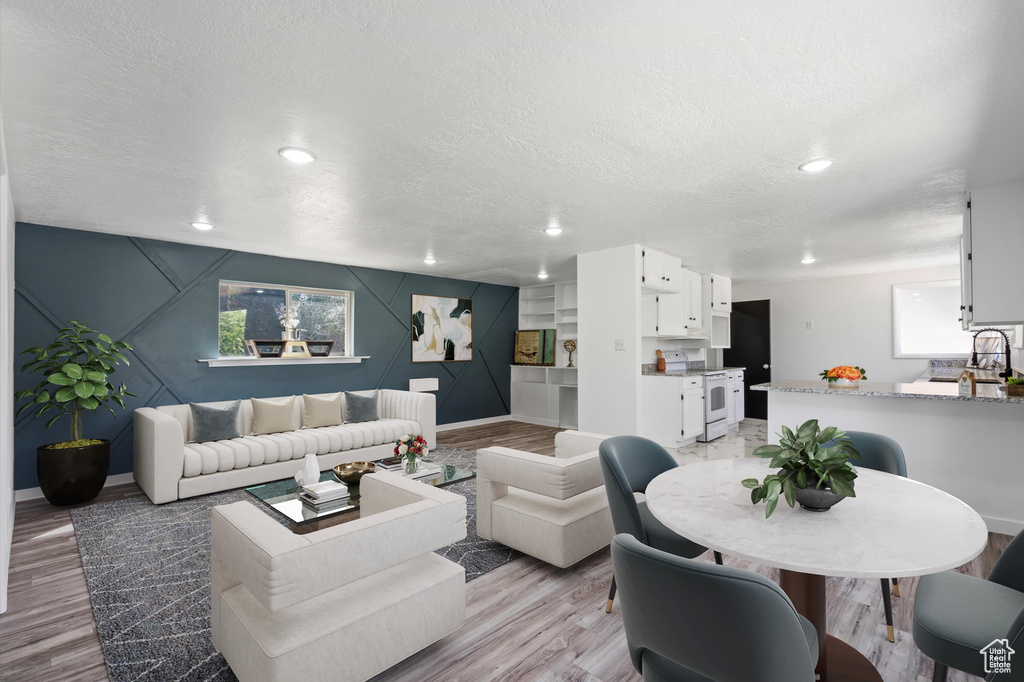 Living room with a textured ceiling and light hardwood / wood-style floors