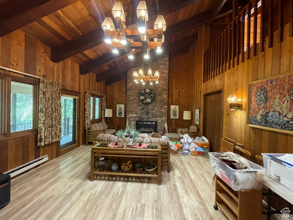 Interior space with a fireplace, vaulted ceiling with beams, and wooden walls