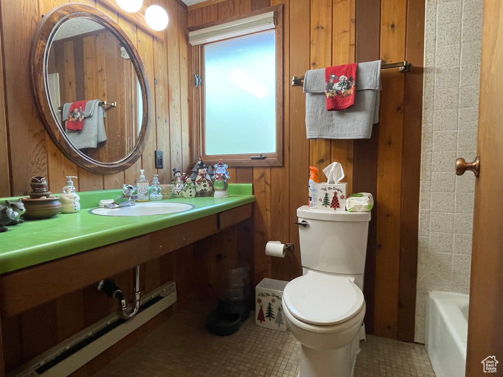 Full bathroom with plus walk in shower, tile patterned floors, toilet, sink, and wood walls