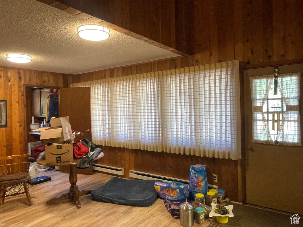 Interior space featuring baseboard heating, hardwood / wood-style floors, and wooden walls